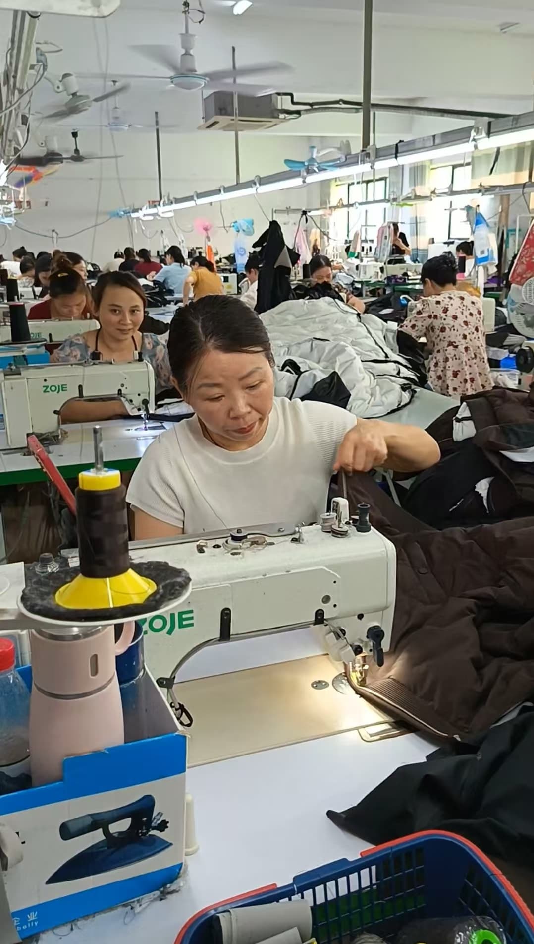Workers and sewing machines on the production floor